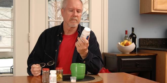 a retired man reading his supplement bottle