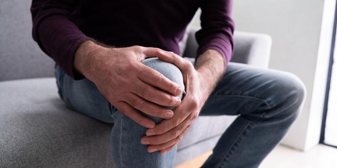 a man holding his knee for support