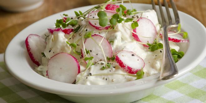 a bowl of potato salad with sliced radish